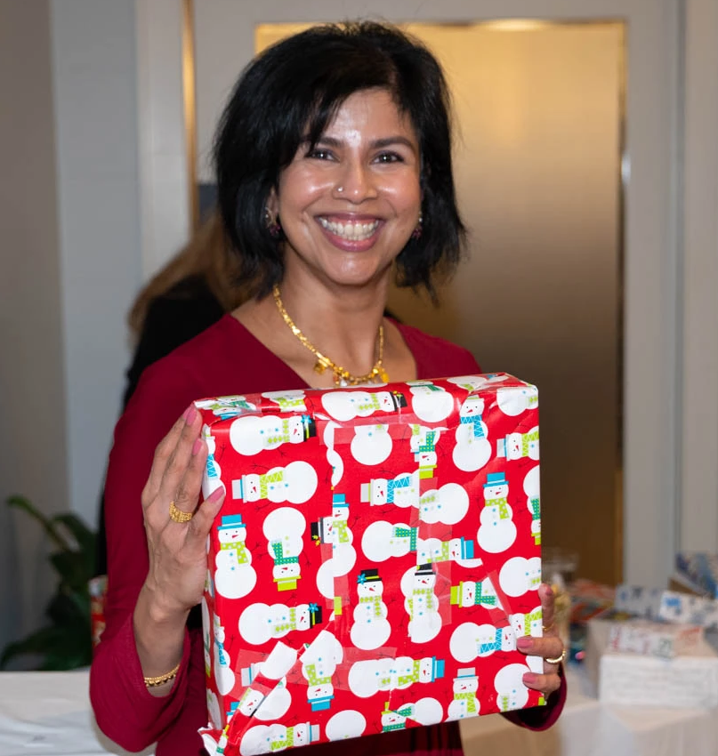 Vidya Sankar holding a gift box and smiling for the camera